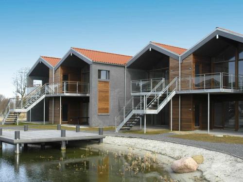ボーゲンセにある4 person holiday home in Bogenseの池を前に建つ建物