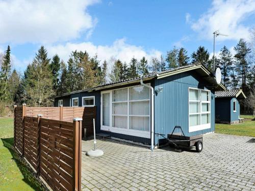 a blue tiny house sitting on a brick driveway at 5 person holiday home in Ans By in Ans