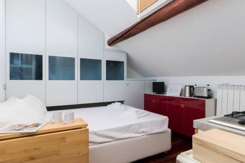 een kamer met een bed en een keuken met witte kasten bij Italianway - Ripa Ticinese 43 in Milaan