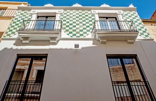 un edificio blanco con ventanas y balcones. en Apartamentos Turísticos Moret11-1A, en Cáceres
