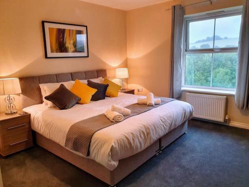 a bedroom with a large bed with two towels on it at Perry House, Long Ashton, Bristol by Cliftonvalley Apartments in Bristol