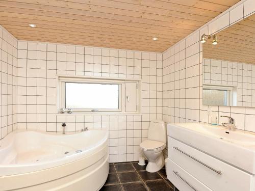 y baño con bañera, aseo y lavamanos. en 8 person holiday home in Sj lund, en Hejls