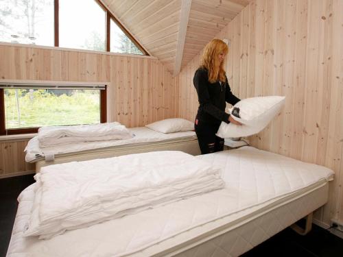 a woman standing in a room with two beds at Four-Bedroom Holiday home in Jerup 3 in Jerup