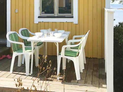 OtterbäckenにあるOne-Bedroom Holiday home in Sjötorpのパティオ(白いテーブル、椅子付)