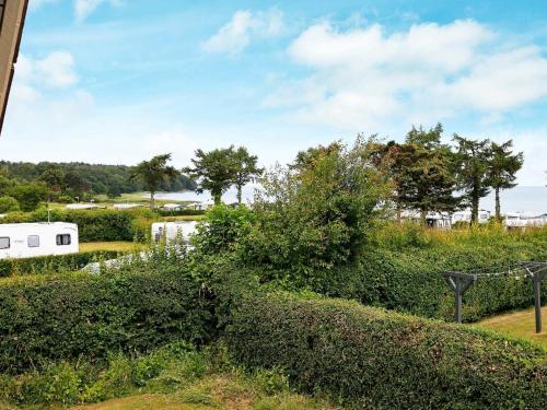 a view of a garden with bushes and trees at 6 person holiday home in Hesselager in Hesselager