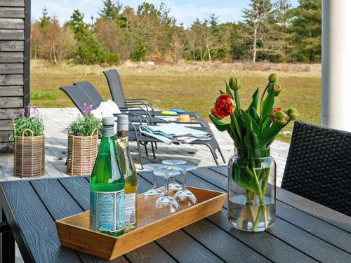 Ålbækにある18 person holiday home in lb kのワイン2本と花瓶