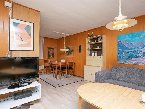 a living room with a couch and a tv and a table at Two-Bedroom Holiday home in Væggerløse 24 in Marielyst