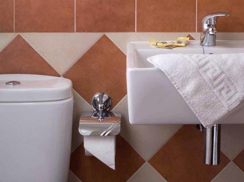 a bathroom with a white sink and a toilet at Hotel Ruta del Poniente in Cuesta de la Palma