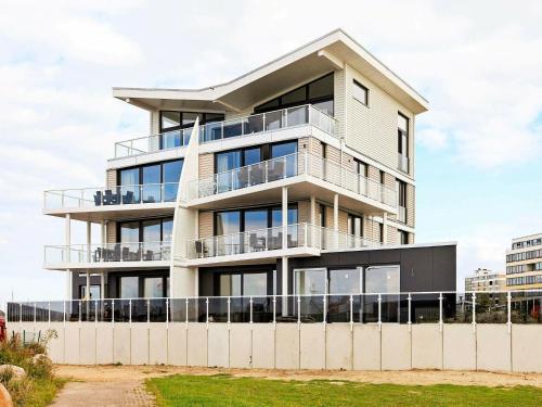 un bâtiment avec des balcons et une clôture devant celui-ci dans l'établissement 6 person holiday home in Wendtorf, à Wendtorf