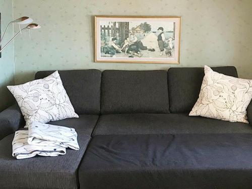 a black couch with pillows in a living room at 4 person holiday home in SJÖTORP-By Traum in Otterbäcken