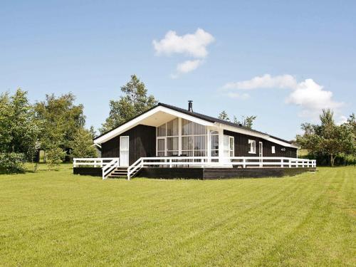ein schwarzes und weißes Haus auf einem Grasfeld in der Unterkunft 6 person holiday home in Fjerritslev in Fjerritslev