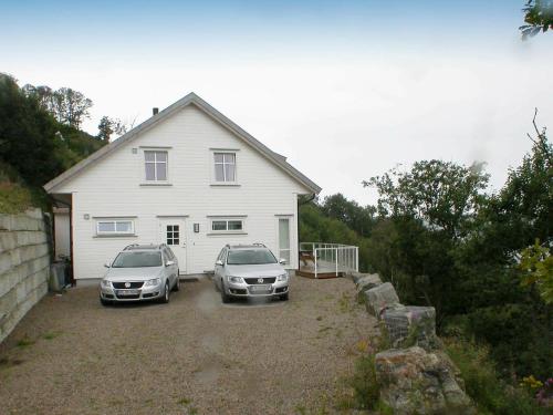 dos autos estacionados frente a una casa blanca en 10 person holiday home in Lindesnes, en Spangereid