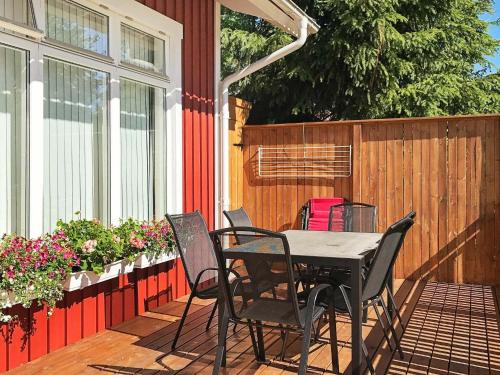 einen Tisch und Stühle auf einer Terrasse mit Blumen in der Unterkunft 5 person holiday home in LIDK PING in Tallbacken