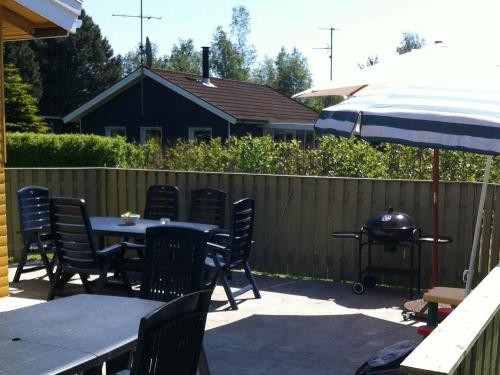 a patio with a table and chairs and a grill at 6 person holiday home in V ggerl se in Bøtø By