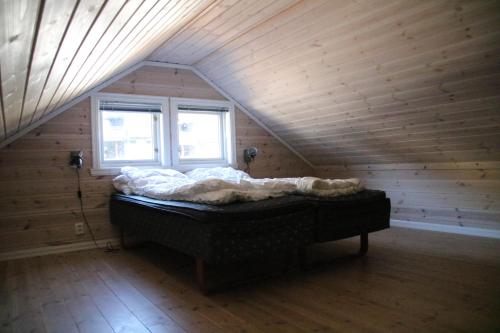 a bedroom with a bed in a wooden attic at Myrkdalen Resort Vårstølen apartment in Vossestrand