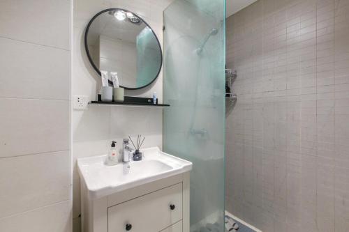 a bathroom with a sink and a mirror and a shower at [Roader] Wuhan Jiang'an District·Hong Kong Road in Wuhan