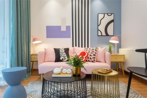 a living room with a pink couch and a table at HeiFei Baohe ·BaiDa shopping mall· in Nanqi