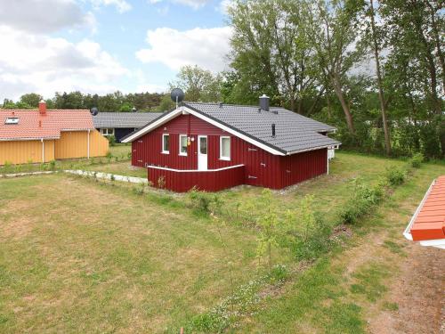 uma casa vermelha num campo com um quintal em 6 person holiday home in GROEMITZ em Grömitz