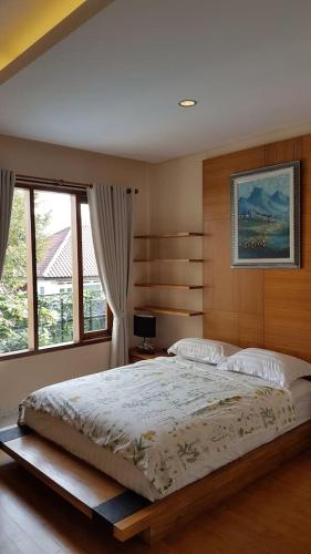 a bedroom with a large bed and a window at Bukit Dago Palace 22 in Bandung