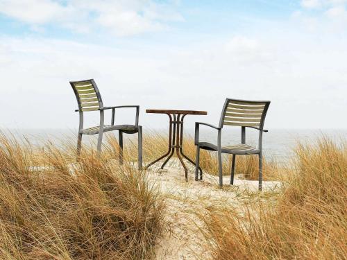twee stoelen en een tafel op het strand bij 6 person holiday home in Bl vand in Blåvand