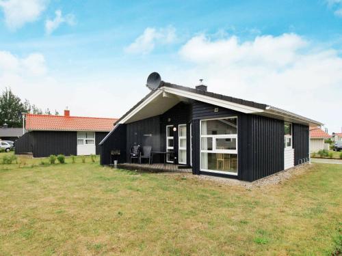 una casa negra con un gran patio en 6 person holiday home in GROEMITZ, en Grömitz