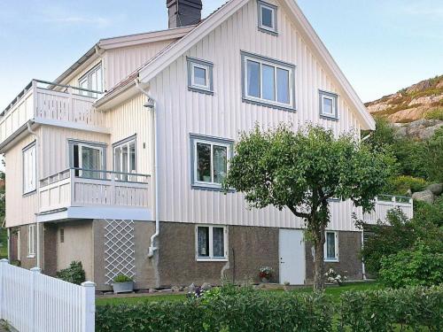 une grande maison blanche avec un arbre en face dans l'établissement 4 person holiday home in Sk rhamn, à Skärhamn