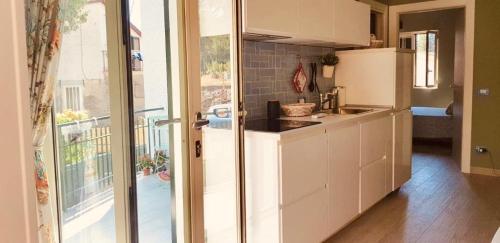 a kitchen with a white refrigerator and a balcony at Casa MARA & Casa TEA in Maratea