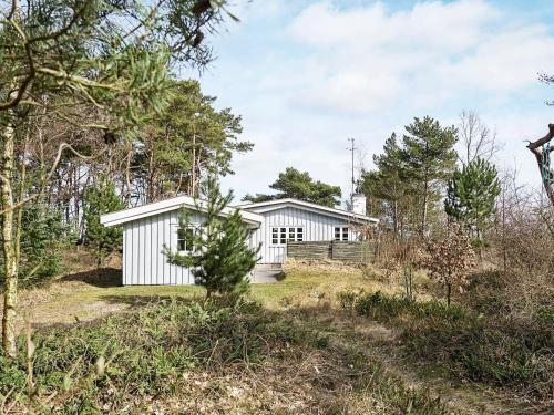 una casa blanca en medio de un bosque en 6 person holiday home in Nex, en Balke