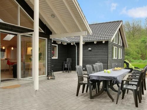 una casa y un patio con mesa y sillas en 18 person holiday home in Tranek r, en Hou