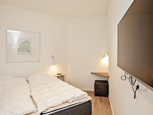 a bedroom with a bed and a flat screen tv at One-Bedroom Holiday home in Wendtorf 1 in Wendtorf