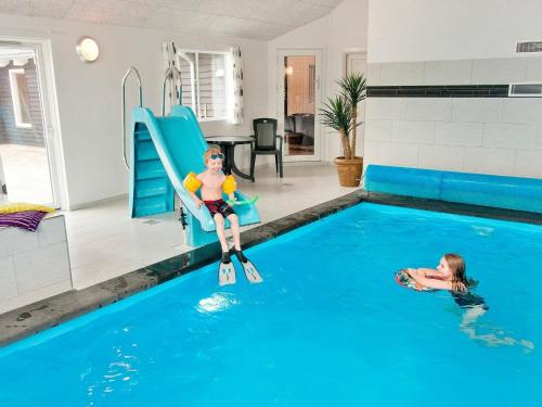 two children playing in a swimming pool at 24 person holiday home in Bl vand in Blåvand