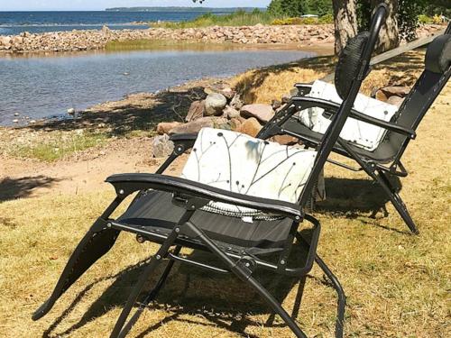 two lawn chairs sitting next to a body of water at 4 person holiday home in SJÖTORP-By Traum in Otterbäcken