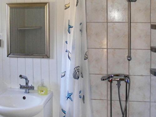 a bathroom with a shower curtain with a sink at Two-Bedroom Holiday home in Vordingborg 2 in Vordingborg