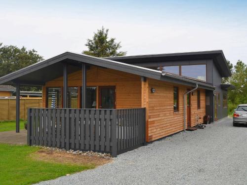 una casa de madera con un coche aparcado delante de ella en 6 person holiday home in Bjert en Sønder Bjert