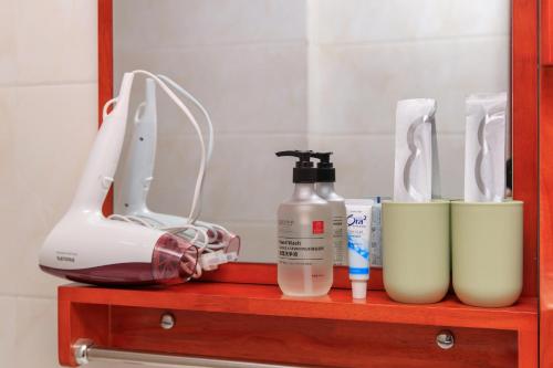 a shelf with a hair dryer and other products on it at Baoding Lianchi·Baoding East Station· in Baoding