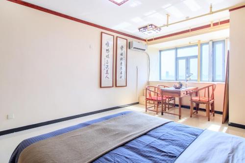een slaapkamer met een bed en een tafel met stoelen bij Baoding Lianchi·Baoding East Station· in Baoding