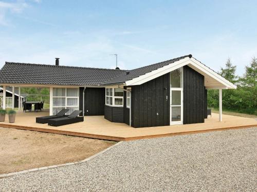 Fjellerupにある8 person holiday home in Glesborgの木製デッキ付き白黒家屋