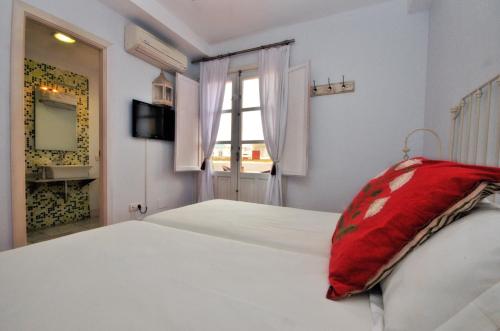 a bedroom with a bed with a red pillow on it at Benali Guest House in Tarifa