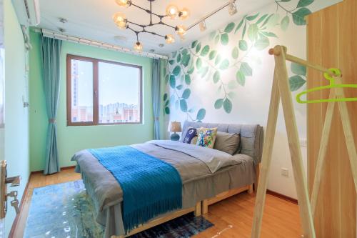 a bedroom with a bed and a tree mural on the wall at Baoding Lianchi·North China Electric Power University· in Baoding
