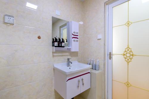 a bathroom with a white sink and a shower at Baoding Lianchi·North China Electric Power University· in Baoding