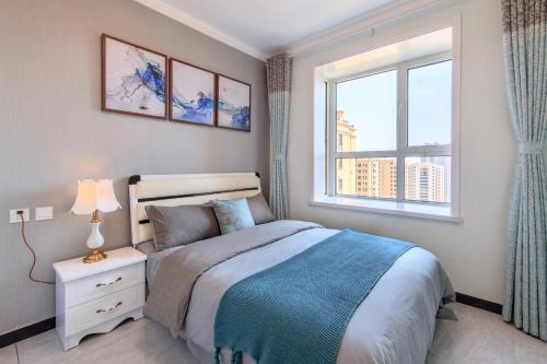 a bedroom with a bed and a window at Baoding Lianchi·Baoding East Station· in Baoding