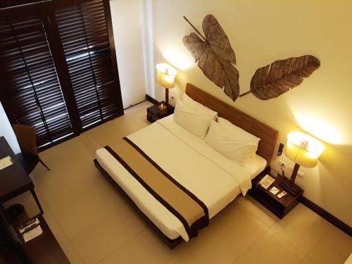 a bedroom with a bed with two lamps and two tables at Kamana Sanctuary Resort & Spa in Olongapo