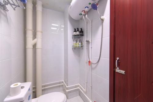 a white bathroom with a shower and a toilet at Baoding Jingxiu·BaoDing Railway Station· in Baoding