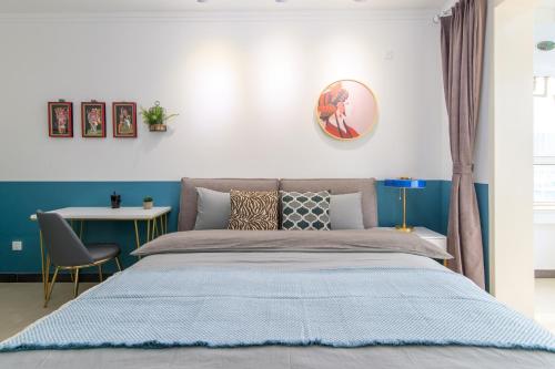 a bedroom with a large bed and a desk at Baoding Jingxiu·Beiguo Shopping Mall· in Baoding