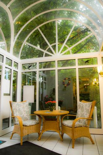 a room with a table and two chairs and a glass ceiling at Hotel Haus am See in Bad Salzuflen