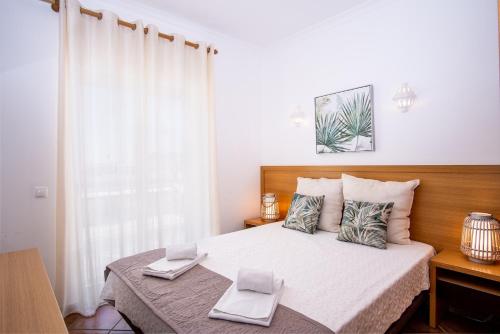a bedroom with a bed with two laptops on it at Jardins Vale de Parra in Albufeira