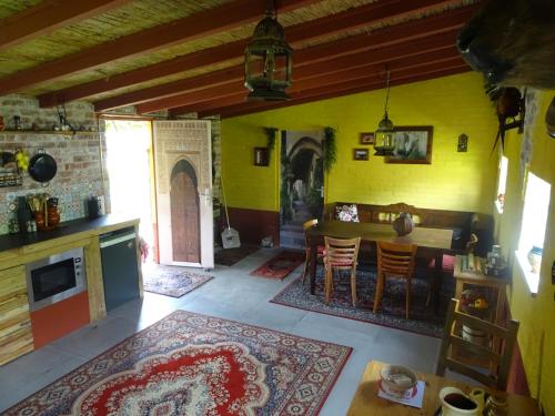 Casa Tranquila في أوآيْ: غرفة معيشة بجدران صفراء وطاولة وكراسي