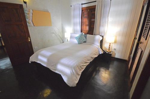 a bedroom with a large white bed with two pillows at Villas Sur Mer in Negril