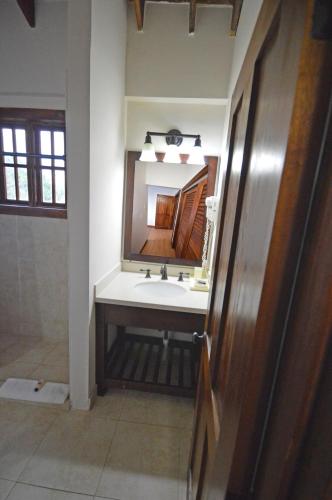 a bathroom with a sink and a mirror at Villas Sur Mer in Negril