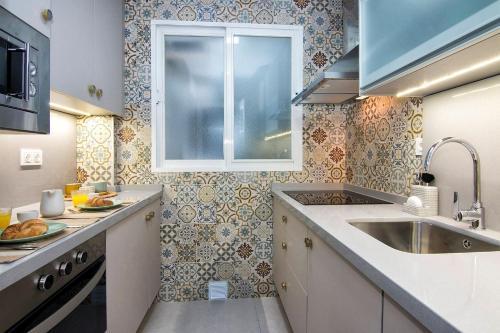 eine Küche mit einem Waschbecken und einem Fenster in der Unterkunft ECO CENTER GRANATENSIS free parking in Granada